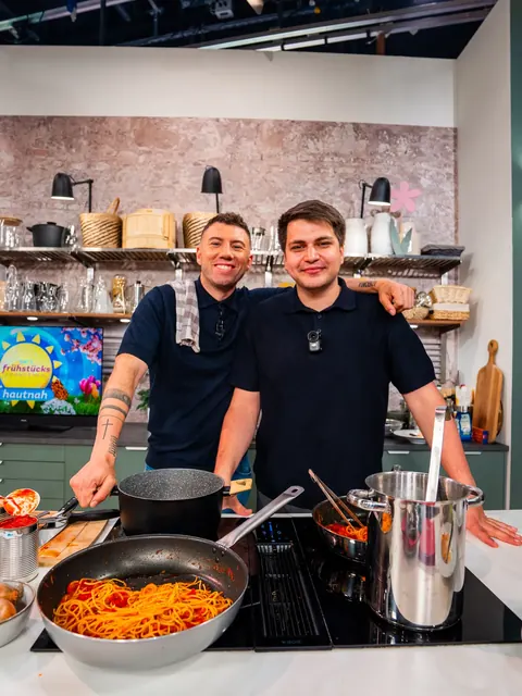 Zwei Köche kochen Pasta vor der Kamera in der Studioküche