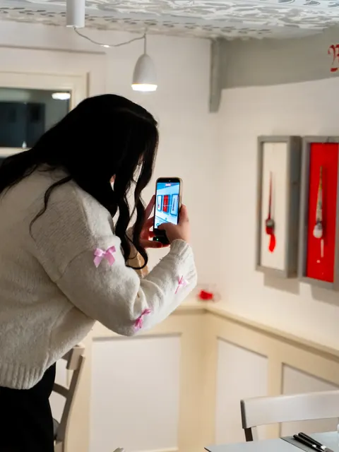 Teammitglied fotografiert mit dem Smartphone Details in einem Restaurant