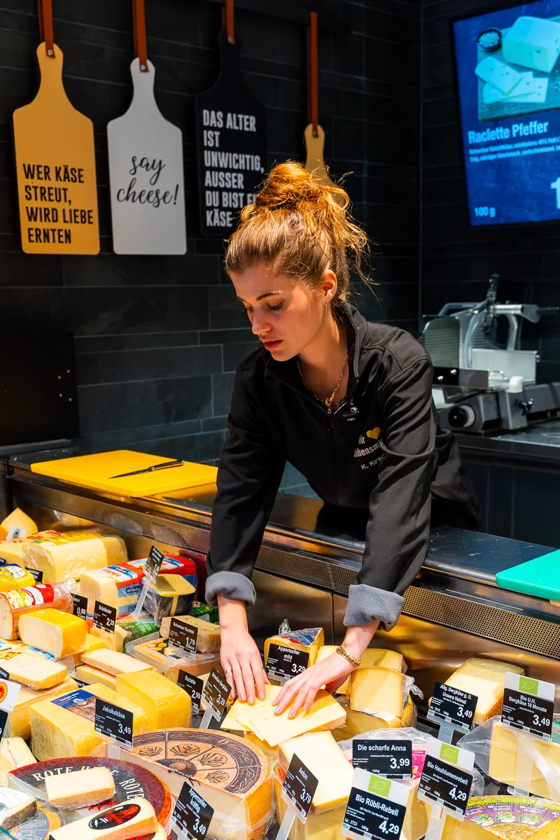 Brandface Lilit richtet an der Käsetheke des EDEKA Fitterer Marktes den Käse an